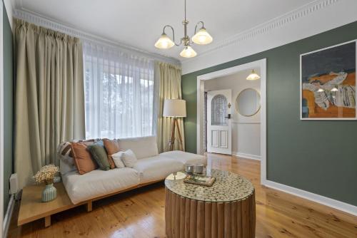 a living room with a couch and a table at Bedford Beauty Stylish Retro Family Home with office in Marion