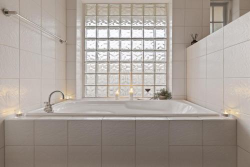a bath tub in a bathroom with a window at Bedford Beauty Stylish Retro Family Home with office in Marion