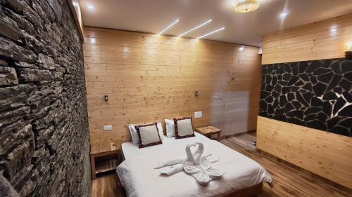 Una habitación con una cama con un lazo encima. en The clifftonn stays, en Jibhi