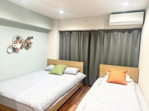 a bedroom with two beds and a window at Aa歌舞伎町 东京最中心 东新宿四分钟 in Wada