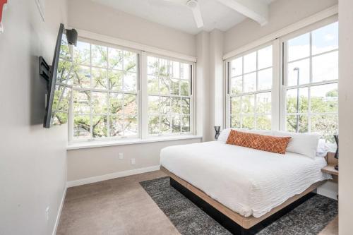 a bedroom with white walls and windows and a bed at The 333 Suites 203 - Stay for 6 in Cincinnati