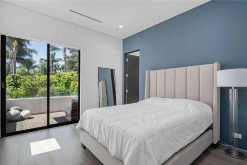 a bedroom with a large bed and a large window at Luxury Escape 6BR Villa Pool, Gym, Theatre, EV in Sherman Oaks