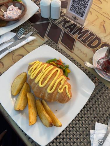 eine Platte mit einem Hot Dog und Pommes frites in der Unterkunft Nefertiti Royal Hotel in Kairo