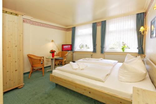 a bedroom with a large bed and a table at Hotel Sonneneck in Zinnowitz