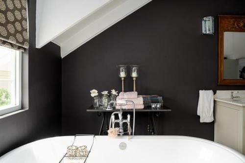 Lagoonside Family Haven في كنيسنا: حمام مع حوض استحمام أبيض ومغسلة