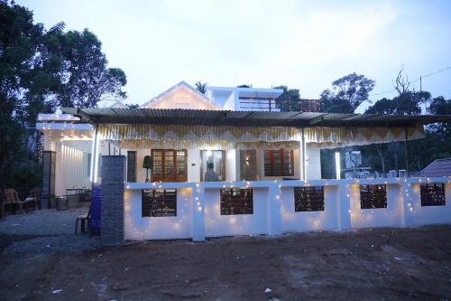 ein weißes Haus mit Lichtern davor in der Unterkunft Grace Home in Ūdumbanshola