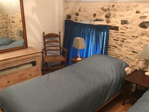 a bedroom with a bed and a mirror and a chair at Lapeyrouse Bonnet in Montmirail