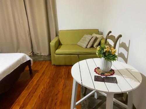 a living room with a green couch and a table at kitnet no centro histórico in São João del Rei