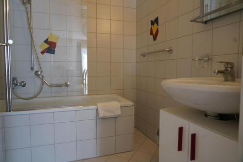 a white bathroom with a sink and a shower at Fee-Rien in Saas-Fee
