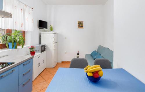 une cuisine avec une table avec un bol de fruits dessus dans l'établissement 1 Bedroom Beautiful Apartment In Fazana, à Fažana