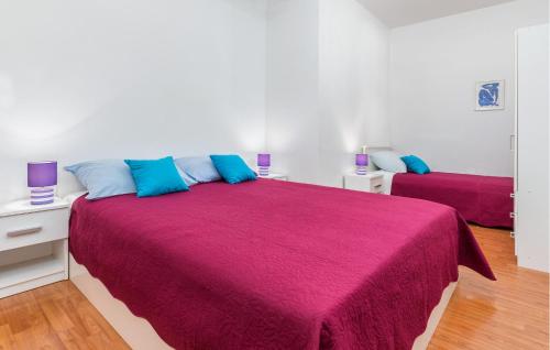 - une chambre avec 2 lits dotés d'oreillers violets et bleus dans l'établissement 1 Bedroom Beautiful Apartment In Fazana, à Fažana