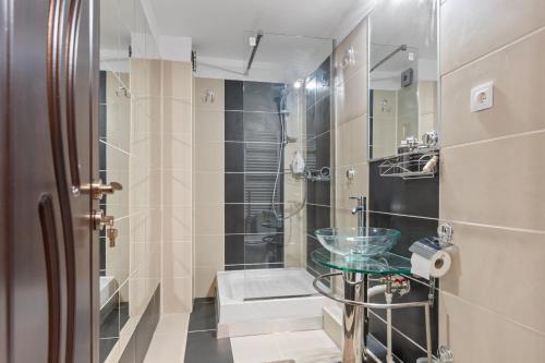 a bathroom with a shower and a glass sink at Modern 1BR Retreat Cofee & Peace in Bucharest