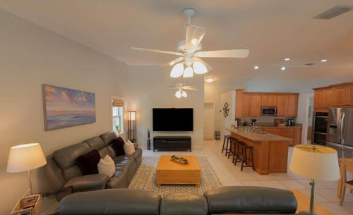 a living room with a couch and a ceiling fan at Poolside Miami Paradise with BBQ & Outdoor Lounge in Country Walk