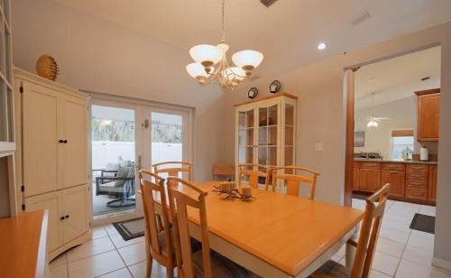 a kitchen and dining room with a wooden table and chairs at Poolside Miami Paradise with BBQ & Outdoor Lounge in Country Walk