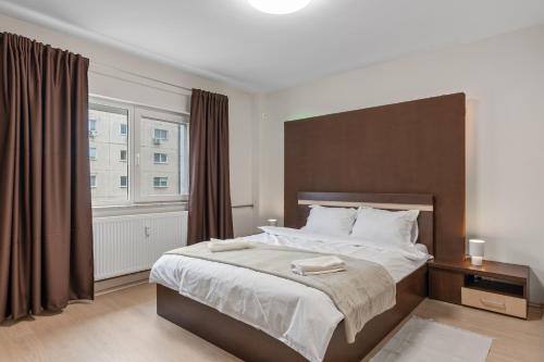 a bedroom with a large bed and a large window at Modern 1BR Retreat Cofee & Peace in Bucharest