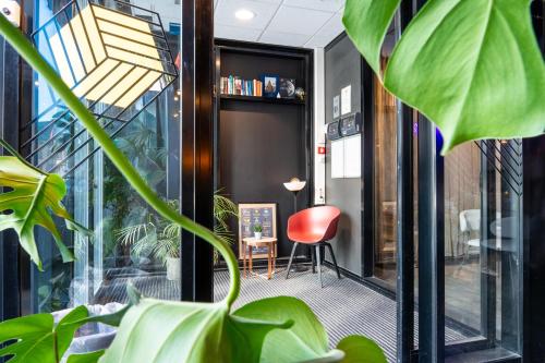 a room with plants and a red chair at Comfort Hotel Xpress Tromsø in Tromsø