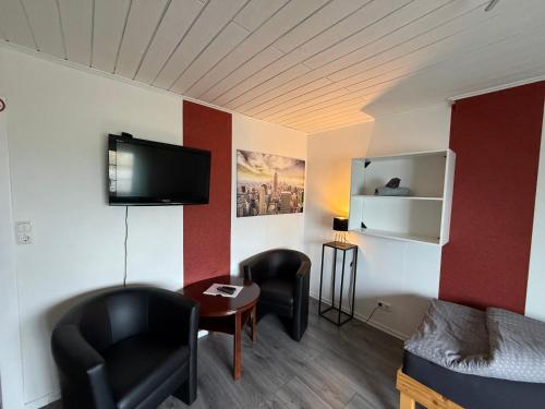 a small room with a bed and a tv on the wall at Zimmer 3 in Bullendorf