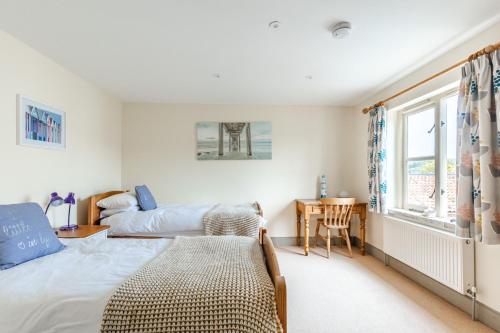 een slaapkamer met een bed en een bureau bij 3 Links Court in Brancaster