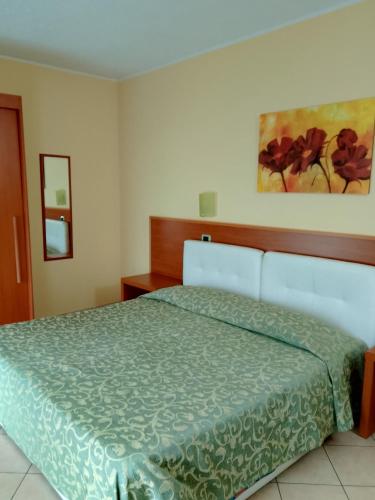 ein Schlafzimmer mit einem Bett mit grüner Bettdecke in der Unterkunft Da Santo Hotel Ristorante Pizzeria in Ferrara