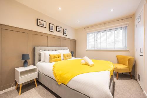 une chambre avec un grand lit avec une couverture jaune dans l'établissement Bright 1-Bed Home with Garden Near Braid Hills Golf Course, à Édimbourg