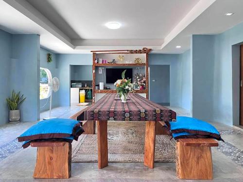 a dining room table with two blue cushioned chairs and a table with a v at 7Sea Beach Pool Villa in Ao Nam Mao