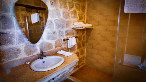 a stone bathroom with a sink and a mirror at Tache By The Lake in Fayoum