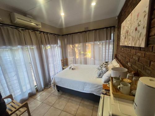 a bedroom with a bed and a brick wall at 39 Shone GH in Postmasburg