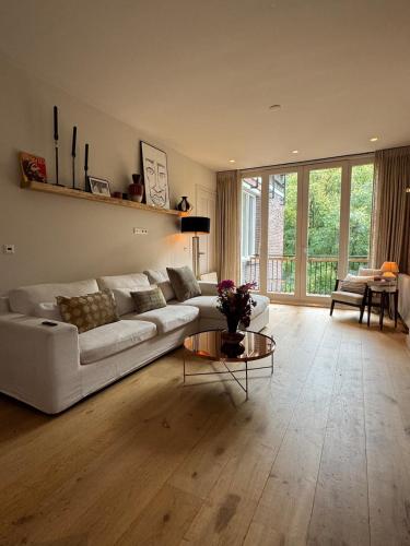 a living room with a white couch and a table at The Park Loft in Amsterdam