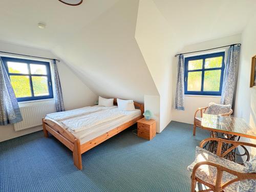 een slaapkamer met een bed en twee ramen bij Ferienhaus Arkona Putgarten in Putgarten