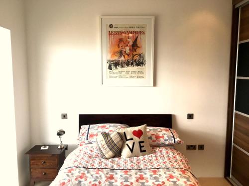 a bedroom with a bed with a movie poster on the wall at Eight Water's Edge in Tenby