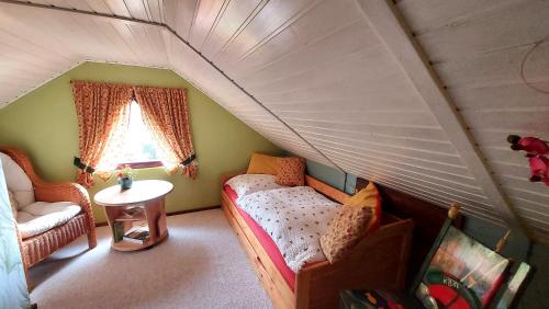 a attic room with a bed and a window at Ferienhaus Julchen Samtens - mit Garten, Grillplatz, Sauna in Samtens