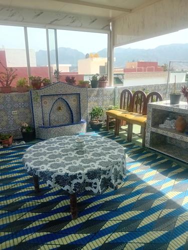 eine Terrasse mit einem Tisch und Stühlen auf dem Dach in der Unterkunft JERDOUH For FAMILY ONLY in Tétouan
