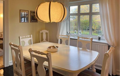 a dining room with a table and chairs and a window at Awesome Home In Skagen With Wifi in Hulsig