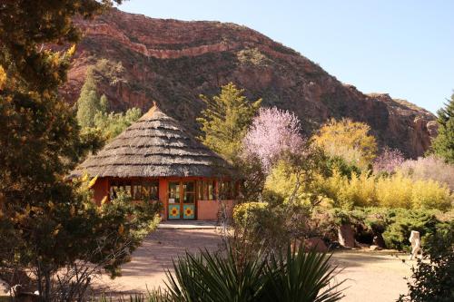 een gebouw met een grasdak voor een berg bij Hunuc Huar PR in San Rafael