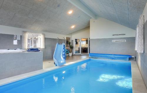 a large swimming pool with a blue pool slide at Amazing Home In Glesborg With Sauna in Fjellerup