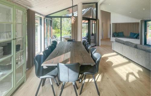 a dining room with a long table and leather chairs at Amazing Home In Sjællands Odde With Sauna in Yderby