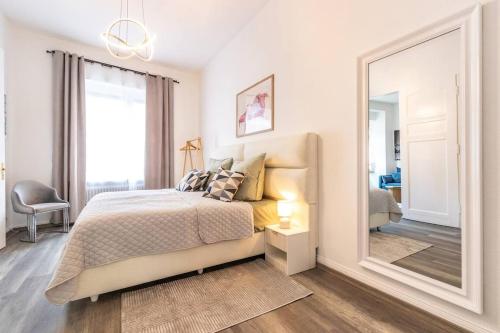 Un dormitorio con una cama y un espejo grande. en Design-Altbaujuwel in Neuwied, en Neuwied