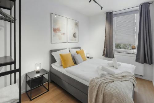 a bedroom with a large bed with yellow pillows at MILPAU Herne1 - Zentrales, modernes Design-Apartment - Smart TV, Nespresso für 4 Personen in Herne