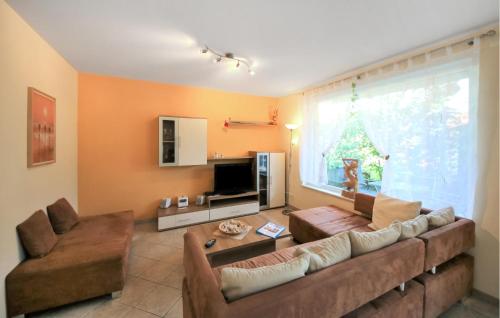 een woonkamer met een bank en een groot raam bij U9 Eg in Marienfelde