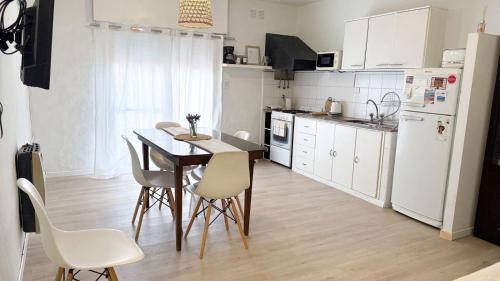 グアレグアイチュにあるDpto Costanera Gualeguaychu Alemのキッチン(ダイニングテーブル、白い電化製品付)