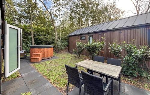 a backyard with a wooden table and chairs and a grill at 3 Bedroom Pet Friendly Home In Oud Gastel in Oud-Gastel