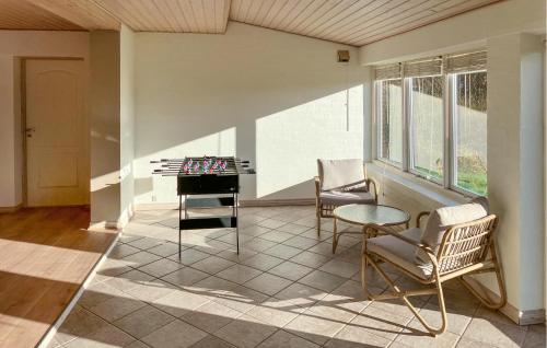 a living room with a table and chairs at 5 Bedroom Awesome Home In Lemvig in Nørby