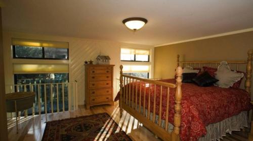 a bedroom with a bed and a dresser and windows at Secluded And Cozy Townhome At Tripp Lake in Chestertown