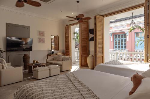 ein Schlafzimmer mit Bett und ein Wohnzimmer in der Unterkunft Hotel Casa Bianca by Faranda Boutique in Cartagena de Indias