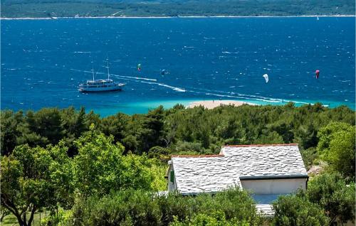 a boat in the water next to a house at Beautiful Home In Bol in Bol