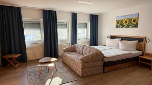 a bedroom with a bed and a chair and a couch at Apartments Potz in Illmitz