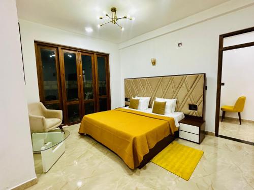 une chambre avec un grand lit avec une couverture jaune dans l'établissement Golden Villa, à Wayikkal
