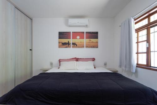 a bedroom with a bed with a black blanket at Sitio com Piscina, Jogos e Espaco Home Office in Cinco Lagos