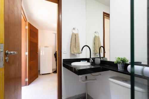 a bathroom with a black counter and a sink at Sitio com Piscina, Jogos e Espaco Home Office in Cinco Lagos
