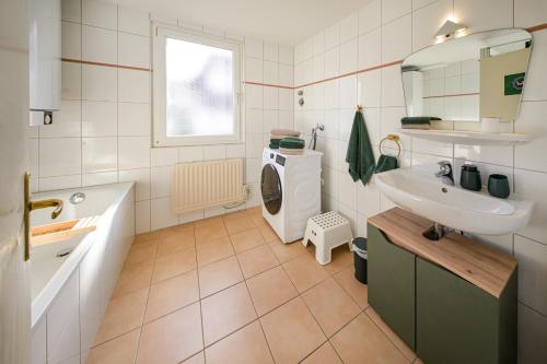 ein Badezimmer mit Waschmaschine und Waschbecken in der Unterkunft Lepold's Balkenzauber - Sasbachwalden zentral, mit Kamin und Weinbergblick, für 6 Personen, familienfreundlich in Sasbachwalden